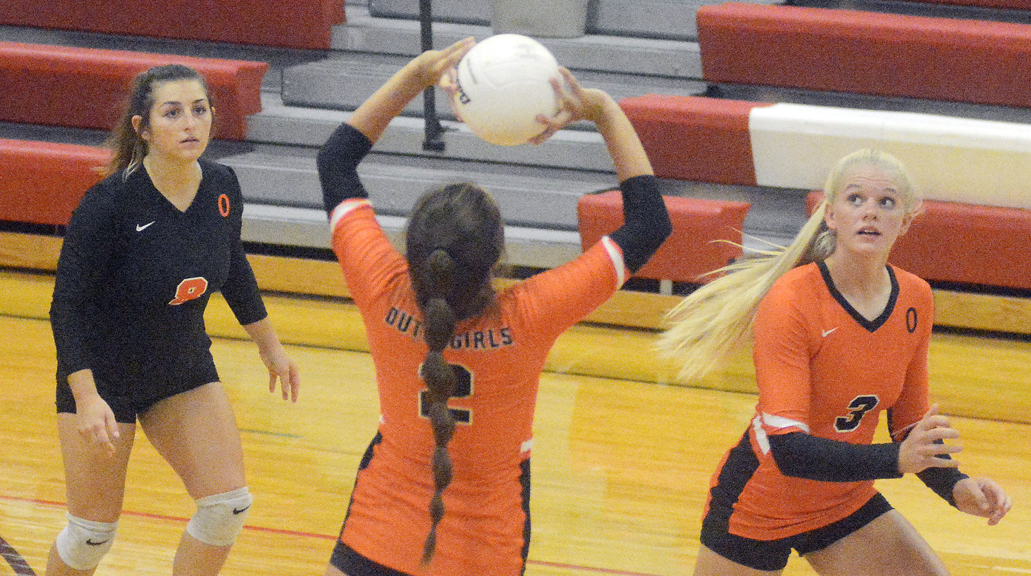 Kylie Kitchen (above, center) sets the ball while Olivia Vandegriffe (above, far left) and Josie Gerlemann (above, far right) watch the ball to see where it is set during Owensville’s three-set victory last Tuesday night in Belle.